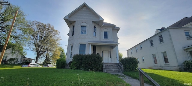 view of front of home featuring brick siding and a front lawn