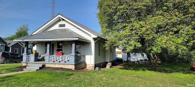 bungalow featuring covered porch and a front yard