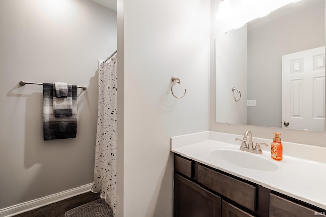 full bathroom featuring baseboards, a shower with shower curtain, and vanity