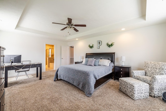 bedroom with carpet floors, recessed lighting, baseboards, ensuite bathroom, and a tray ceiling