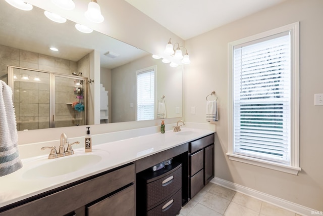 full bathroom with a sink, baseboards, tile patterned flooring, and a stall shower