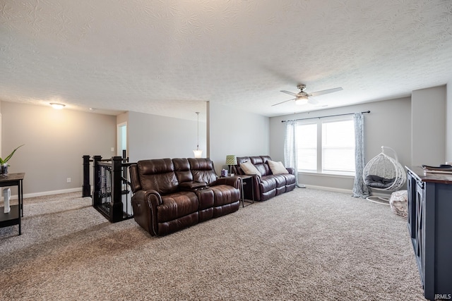 carpeted living area featuring baseboards, ceiling fan, and a textured ceiling