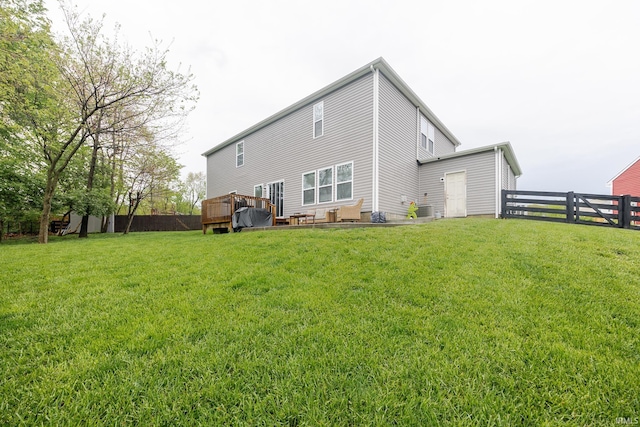 rear view of property featuring a yard, central AC, a wooden deck, and a fenced backyard