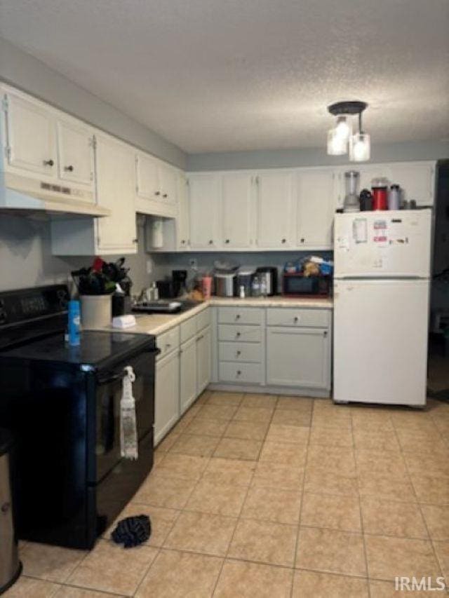 kitchen featuring black range with electric stovetop, light tile patterned floors, white cabinets, freestanding refrigerator, and under cabinet range hood