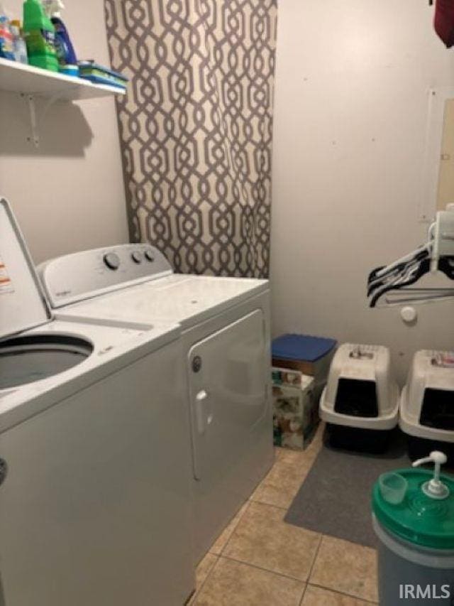 laundry area featuring light tile patterned floors, laundry area, and washer and clothes dryer