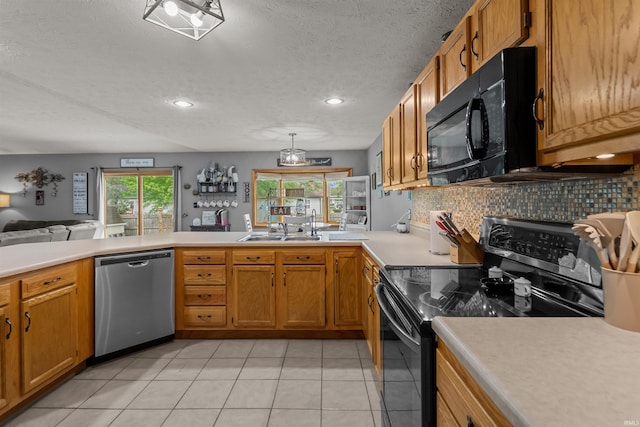 kitchen with backsplash, a textured ceiling, light countertops, a sink, and black appliances