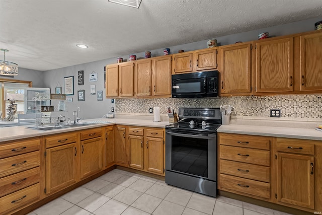 kitchen with a sink, decorative backsplash, black appliances, and light countertops