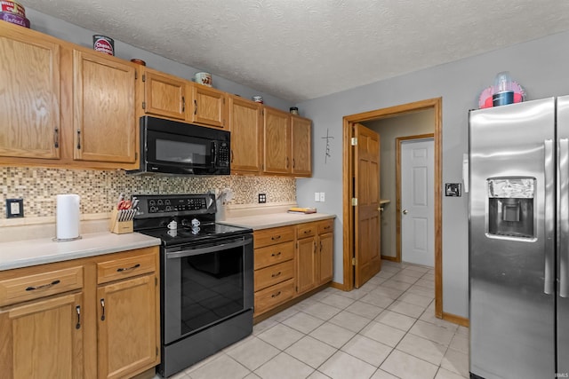 kitchen featuring light countertops, appliances with stainless steel finishes, light tile patterned flooring, and tasteful backsplash