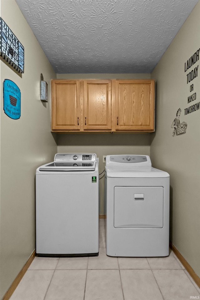 laundry room featuring cabinet space, a textured ceiling, baseboards, and washer and dryer