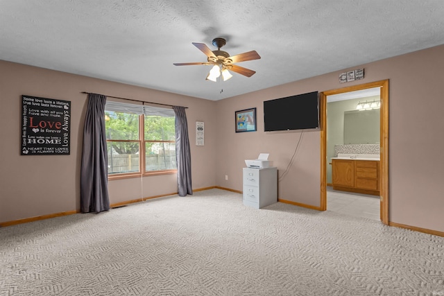 empty room featuring baseboards, a textured ceiling, ceiling fan, and light colored carpet