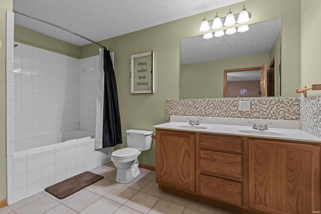 bathroom with a sink, tile patterned flooring, double vanity, toilet, and decorative backsplash