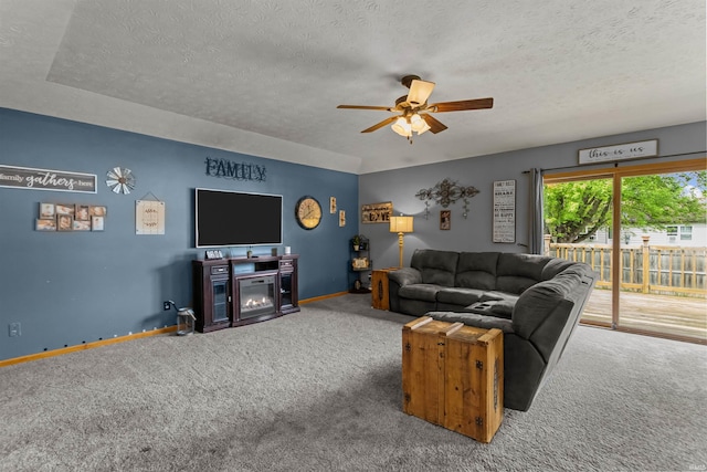 living area with carpet floors, a textured ceiling, ceiling fan, and baseboards