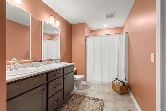 full bath featuring visible vents, a sink, double vanity, and toilet