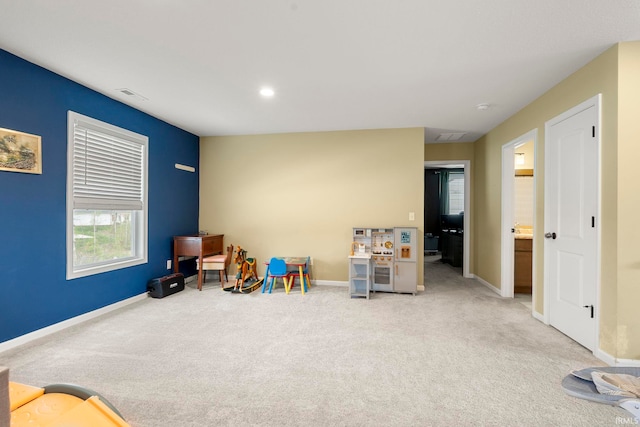 recreation room featuring carpet flooring, baseboards, visible vents, and a wealth of natural light