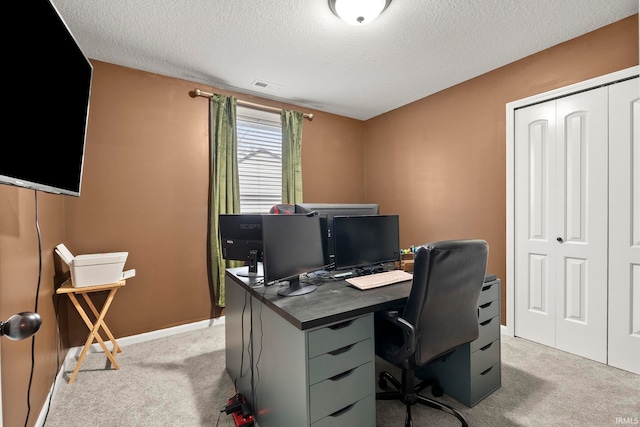 office area featuring visible vents, a textured ceiling, baseboards, and light carpet