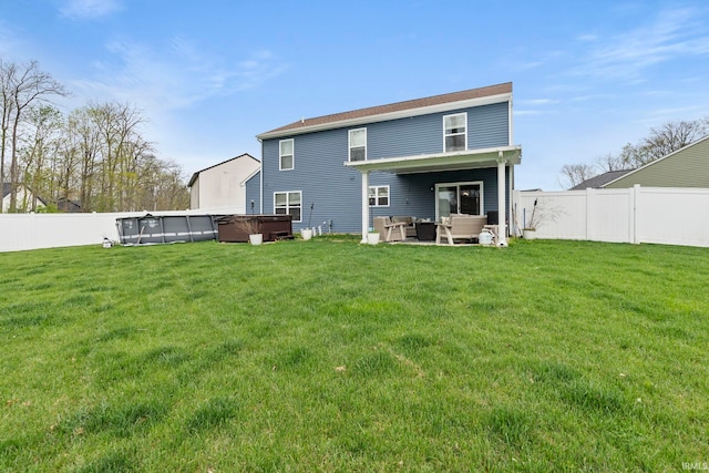 rear view of property with a hot tub, a yard, an outdoor hangout area, and a fenced backyard