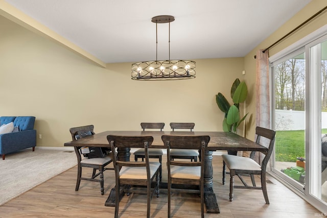 dining space featuring baseboards and light wood-style flooring