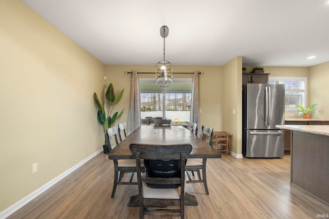 dining area featuring baseboards and light wood-type flooring