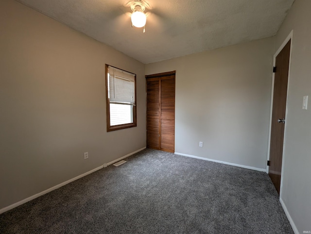 unfurnished bedroom featuring a ceiling fan, visible vents, carpet floors, baseboards, and a closet