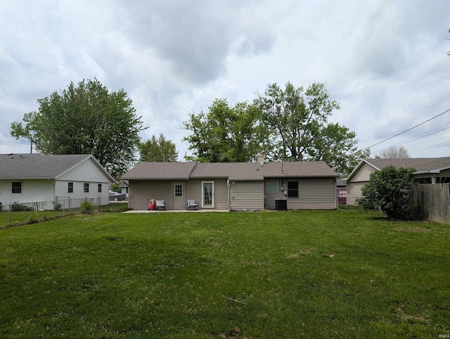 back of house featuring a lawn, fence, and a patio area