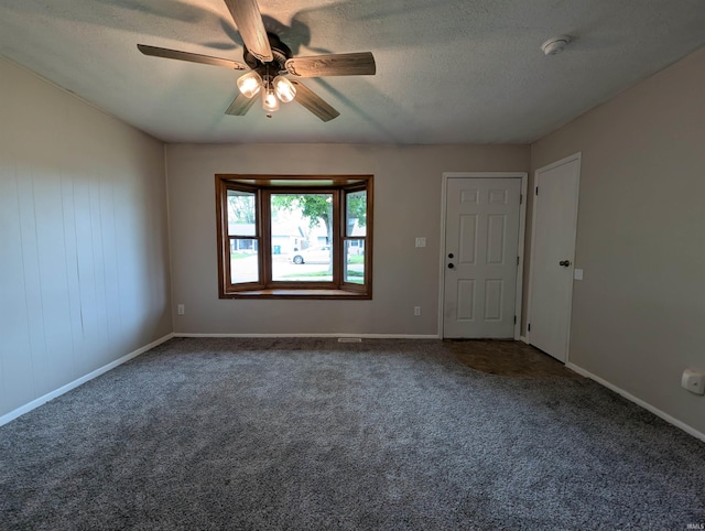 empty room featuring ceiling fan, carpet flooring, and a textured ceiling