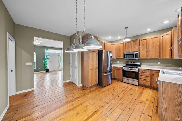 kitchen featuring light wood-type flooring, a sink, light countertops, and stainless steel appliances