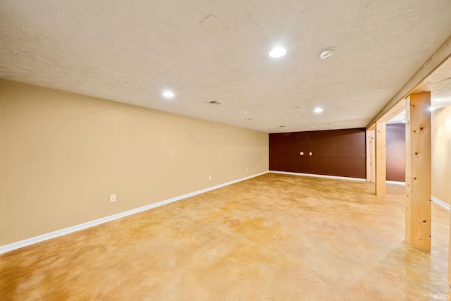 finished basement featuring baseboards, recessed lighting, and a textured ceiling