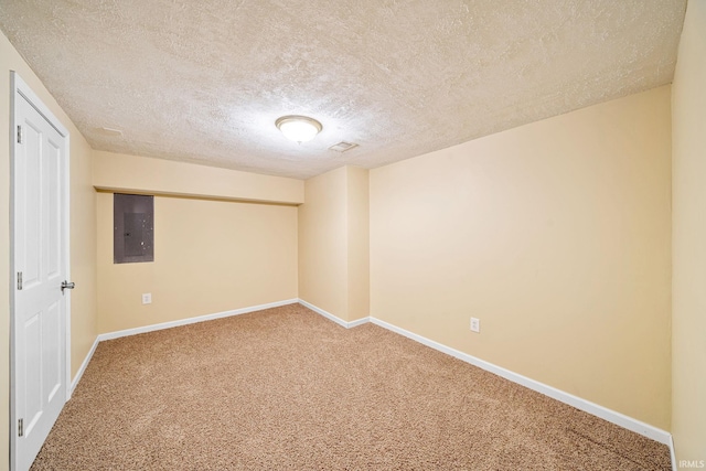 carpeted empty room featuring baseboards, electric panel, and a textured ceiling