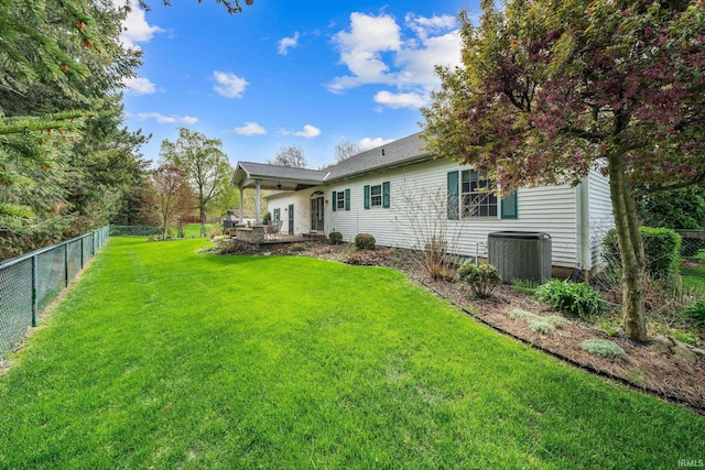 view of yard featuring ceiling fan, central AC unit, and a fenced backyard