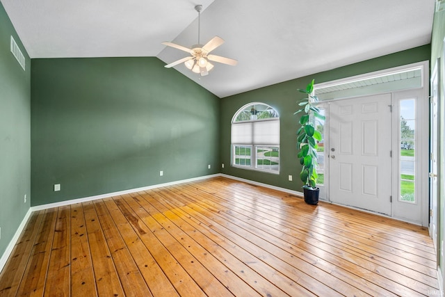 interior space featuring a ceiling fan, visible vents, vaulted ceiling, hardwood / wood-style flooring, and baseboards
