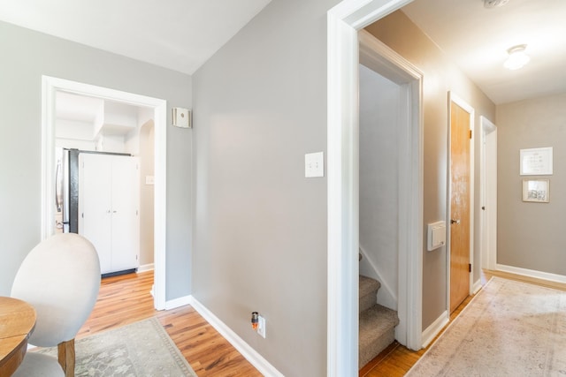 corridor featuring light wood-style floors and baseboards
