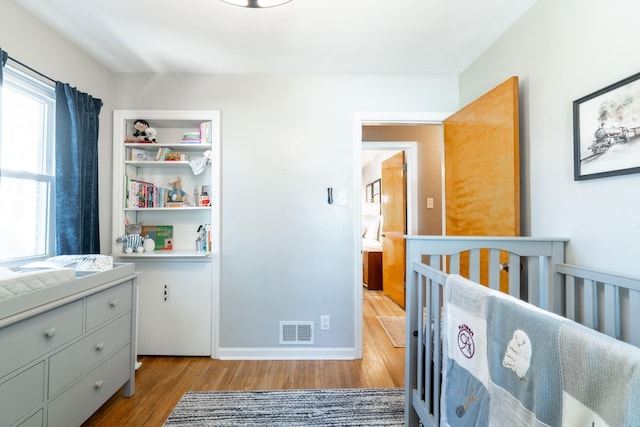 bedroom with visible vents and wood finished floors