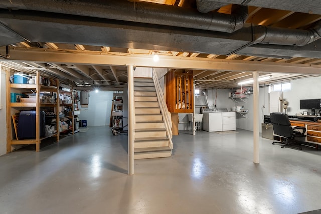 basement featuring separate washer and dryer, a sink, stairway, and electric panel