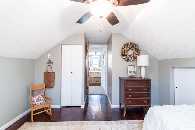 bedroom with baseboards, wood finished floors, and lofted ceiling