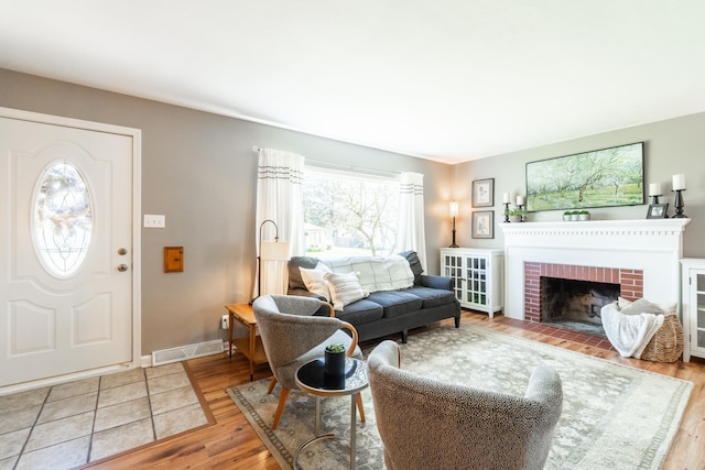 living room with baseboards, a fireplace, and wood finished floors