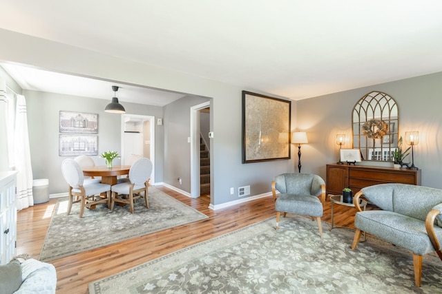interior space featuring baseboards, stairs, wood finished floors, and visible vents
