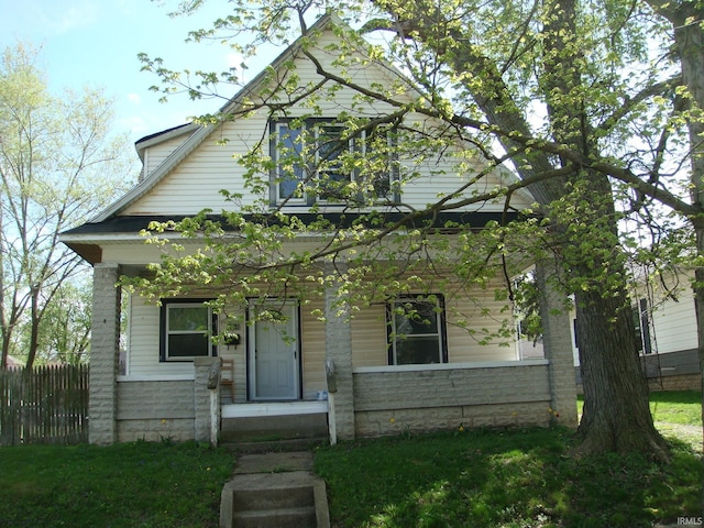 view of front facade featuring covered porch and fence
