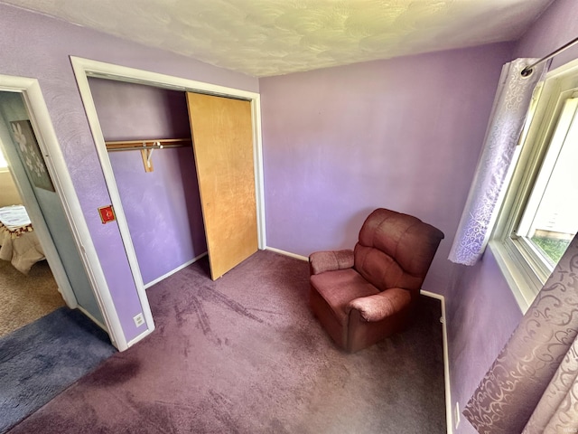 living area featuring carpet floors, a textured ceiling, and baseboards