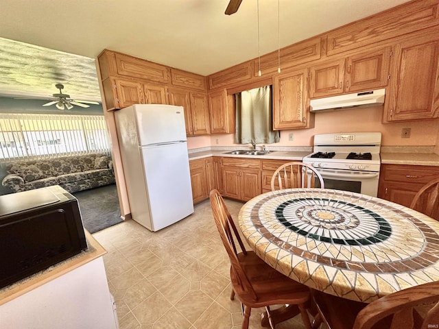 kitchen featuring a ceiling fan, a sink, under cabinet range hood, and white appliances
