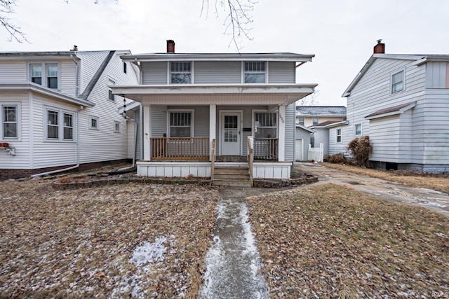 view of front of home with a chimney and a porch