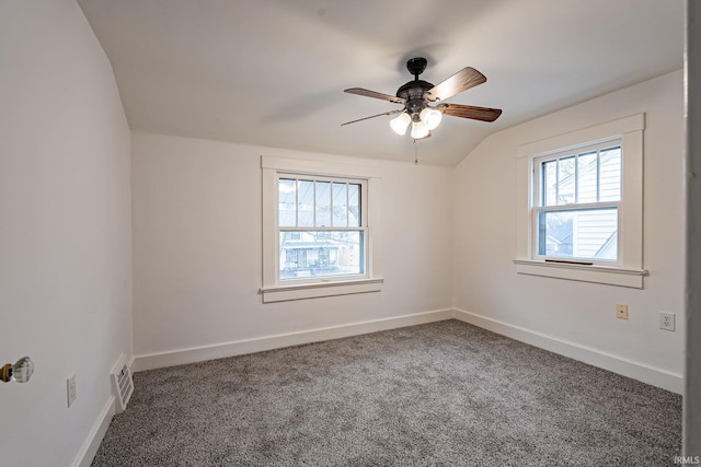 unfurnished room featuring visible vents, carpet flooring, ceiling fan, and vaulted ceiling
