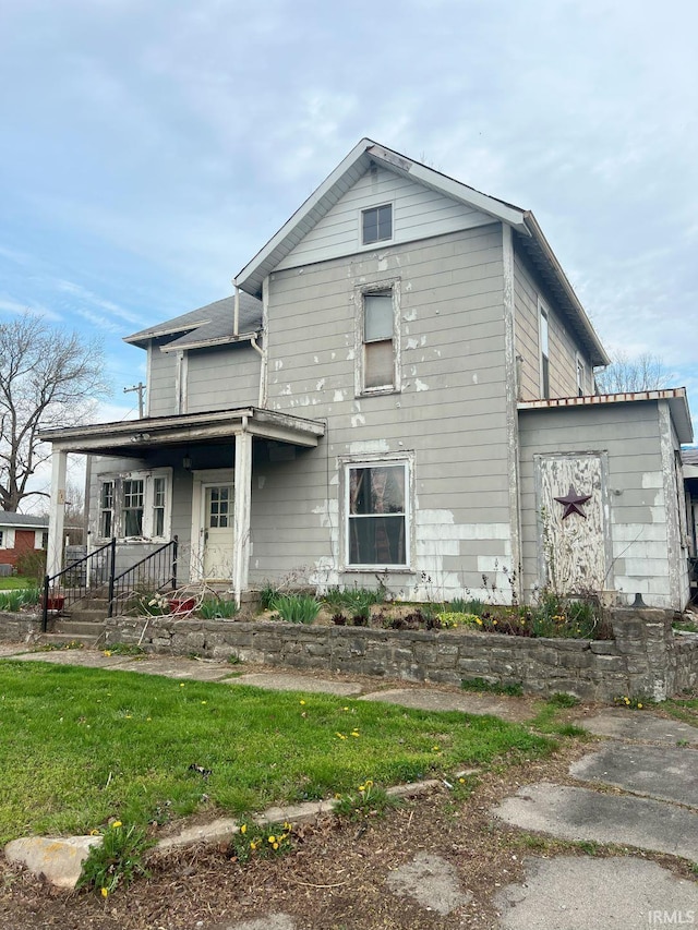 view of front of property with covered porch and a front lawn
