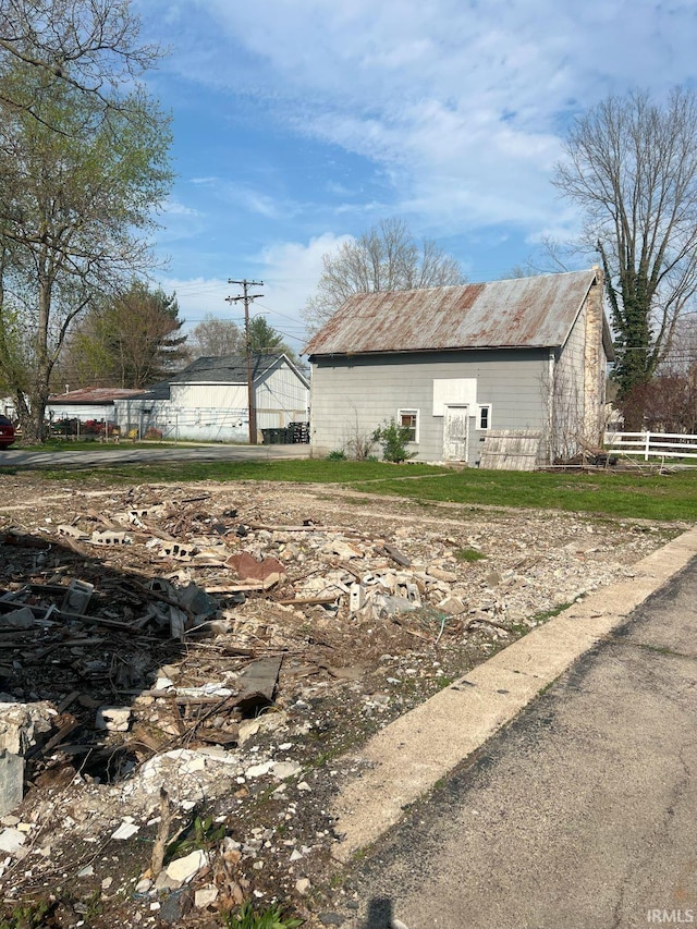 view of side of property featuring an outdoor structure, fence, and an outbuilding