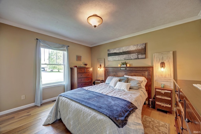 bedroom featuring crown molding, a textured ceiling, baseboards, and light wood-type flooring
