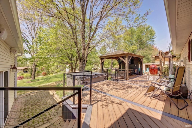 wooden terrace featuring a gazebo and a hot tub