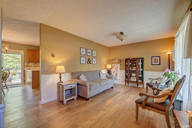 living area featuring light wood-style floors and wainscoting