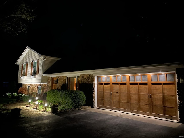 view of front facade with a garage and stone siding