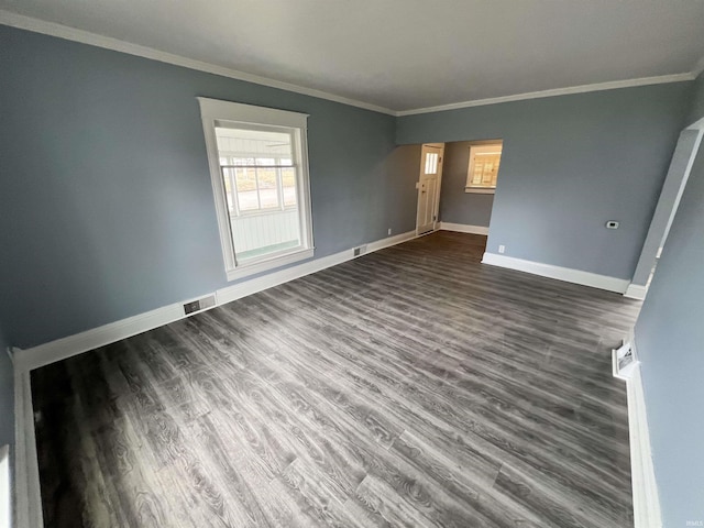 spare room with baseboards, ornamental molding, and visible vents
