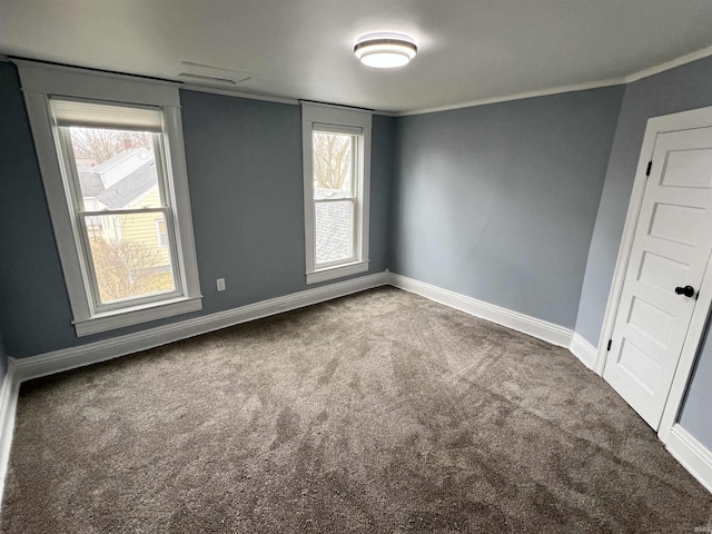 empty room with baseboards, ornamental molding, and carpet flooring