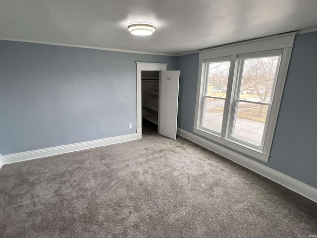 unfurnished bedroom with crown molding, baseboards, and carpet flooring
